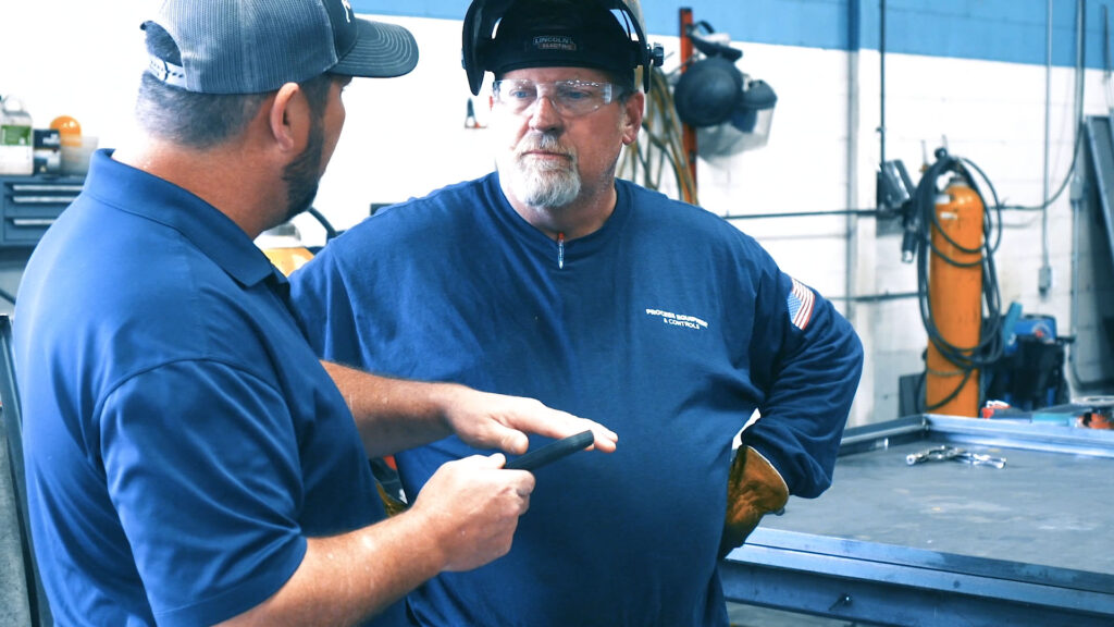 PEC Custom Metal Fabricators consulting together in workshop